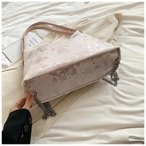 Macro view of butterfly prints and silver metallic foil details on pink tote bag texture