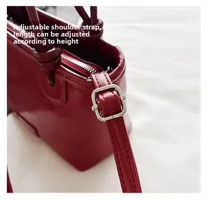 Détails du sac en cuir verni bordeaux montrant la bandoulière réglable et boucle