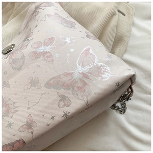 Detail of pink butterfly pattern tote bag with silver chain strap and metal clasp