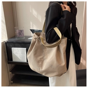 Detail of high-capacity beige tote bag showing soft texture and thick shoulder strap