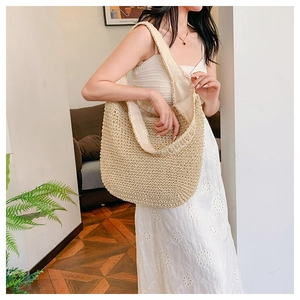Straw tote bag detail showing large capacity and natural fiber texture on shoulder