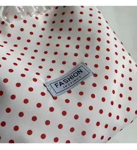 Detail of polka dot nylon bucket bag with mesh ruffle trim and pearl accents