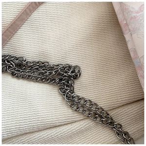 Detail of multi-layer gunmetal chain strap on a floral print tote bag close-up view