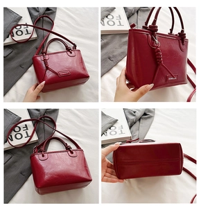 Détail d'un sac seau rouge foncé avec similicuir texturé et poignée à nœud élégante