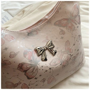 Close-up of pink butterfly tote with silver metal bow clasp and celestial star patterns