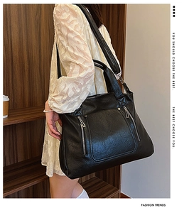 Detail of a large black textured PU leather tote bag with stylish vertical zippers