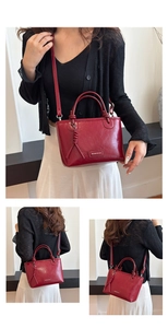 Vue détaillée du sac seau en cuir rouge brillant avec des pompons tressés et du métal