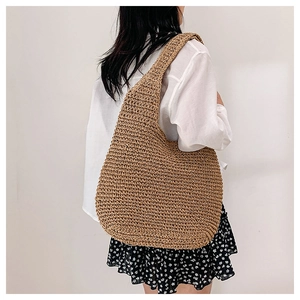 Detail shot of the hand-woven texture and hobo shape of the large straw tote bag