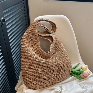 Close-up of woven straw hobo bag on a white chair with tulips and soft lighting