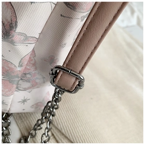 Detail of silver metal chain strap and butterfly print fabric on white tote bag