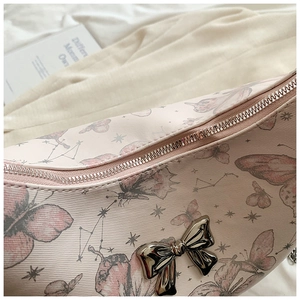 Detailed view of pink butterfly print tote with polished silver bow ornament