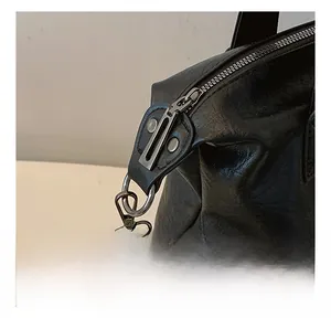 Detail of high-quality black leather texture with gunmetal gray metallic hook and zipper