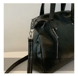 Detail view of smooth black PU leather texture with silver rivets and metal shoulder strap buckle