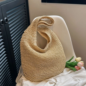 Close-up of a beige straw tote bag with woven texture and a soft inner lining