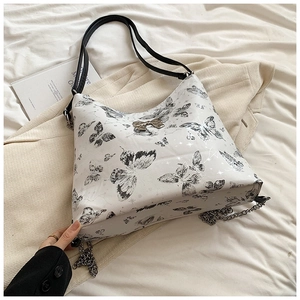 Detail of white PU shoulder bag with butterfly print and chunky silver metal chain link