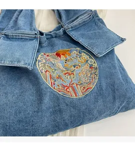 Gros plan d'un sac cabas en denim bleu avec broderie traditionnelle dragon et phénix