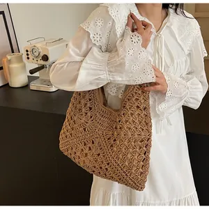 Close-up of brown hand-woven straw tote bag with intricate hollow diamond pattern