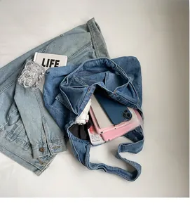 Detail of spacious denim tote bag interior showing capacity for electronics and daily items