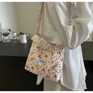 Detail showing red floral patterns and white lace ruffles with pearls on the nylon bag