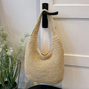 Detailed macro view of the handwoven texture and natural hollow crochet pattern of the tote bag
