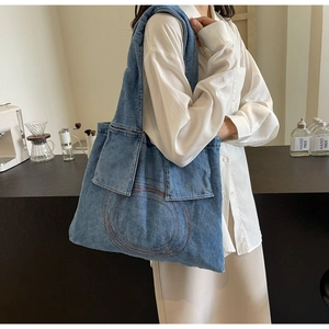 Detail of blue denim tote bag with red embroidered circles and spacious interior
