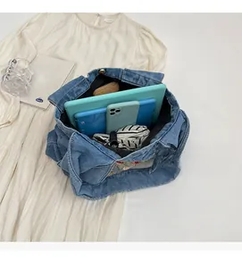 Détail de l'intérieur du sac fourre-tout en jean bleu clair avec grande capacité et broderie