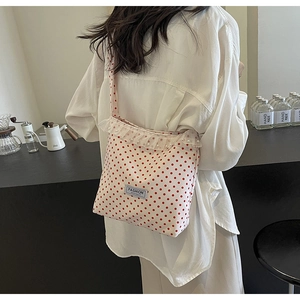 Dettaglio della borsa a secchiello a pois rossi con bordo in pizzo e decori di perle