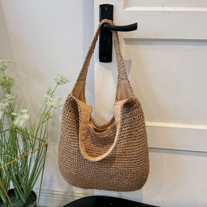 Macro detail of hand-woven straw hobo bag showing crochet texture and fabric lining