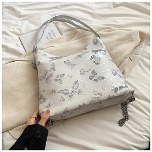 Detailed close-up of a butterfly print tote bag with silver chain accessory and wide strap