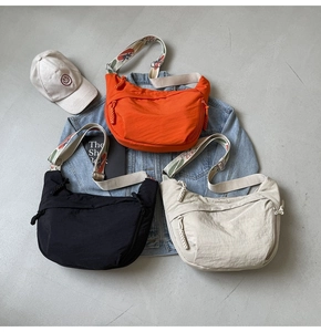 Nylon crescent crossbody bags with wide patterned straps in black, orange, and beige colors