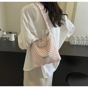 Detail of white red polka dot canvas bag with delicate lace trim and pearl accents