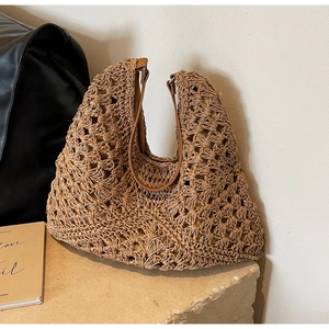 Close-up of hollow out woven texture and brown leather strap on summer tote bag