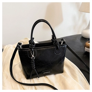 Détail du sac cabas noir avec texture plissée rétro et poignées décoratives à nœuds