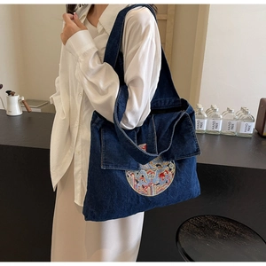 Détail du sac cabas en jean bleu foncé avec broderie de dragon circulaire complexe