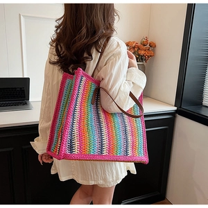 Detail of colorful rainbow striped crochet tote bag with durable brown leather handles