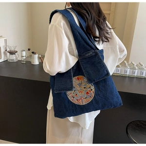 Détail du grand sac cabas en jean bleu avec broderie ethnique et larges bandoulières