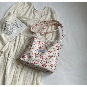 Floral canvas crossbody bag with delicate lace trim and a stylish cream floral pattern