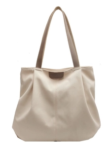 Minimalist canvas tote bag with brown leather handles and spacious interior design