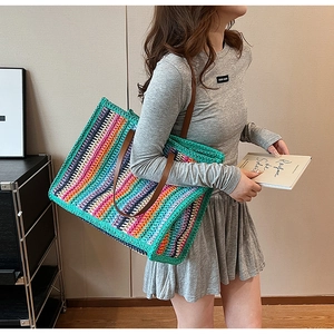 Detail of colorful striped woven tote bag with brown leather straps and vibrant wave patterns