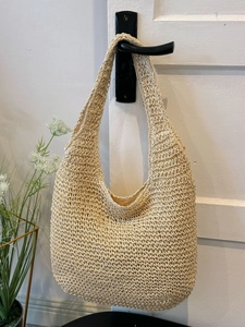 Handmade hollow straw woven tote bag in creamy beige for summer beach vacations