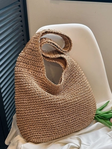 Handwoven straw hobo tote bag in brown with wide shoulder strap and natural raffia texture
