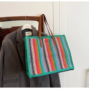 Macro detail of multi-color woven striped tote bag with premium brown leather straps