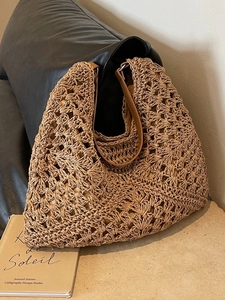 Large straw woven tote bag with hollow crochet pattern and leather straps for summer beach