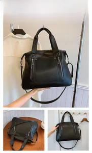 Detail view of large black tote bag with dual front zippers and adjustable shoulder strap