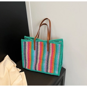Detail of colorful striped woven tote bag with brown faux leather handles for summer