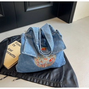 Détail du sac cabas en denim bleu clair avec col de chemise et broderie florale