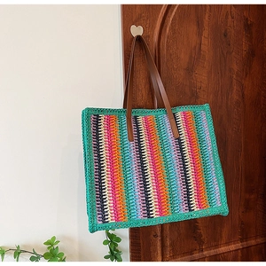 Detail of colorful striped hand-woven tote bag texture with brown leather handles