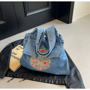 Détail du sac cabas en denim bleu avec broderie chinoise traditionnelle colorée
