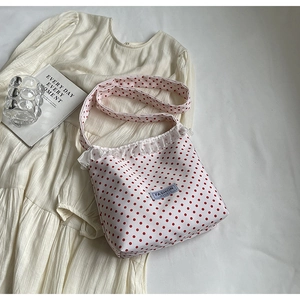 White canvas crossbody bag with red polka dots and delicate white lace trim detail