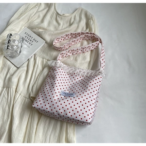 Dettaglio della borsa a secchiello in nylon a pois rossi con pizzo e perle